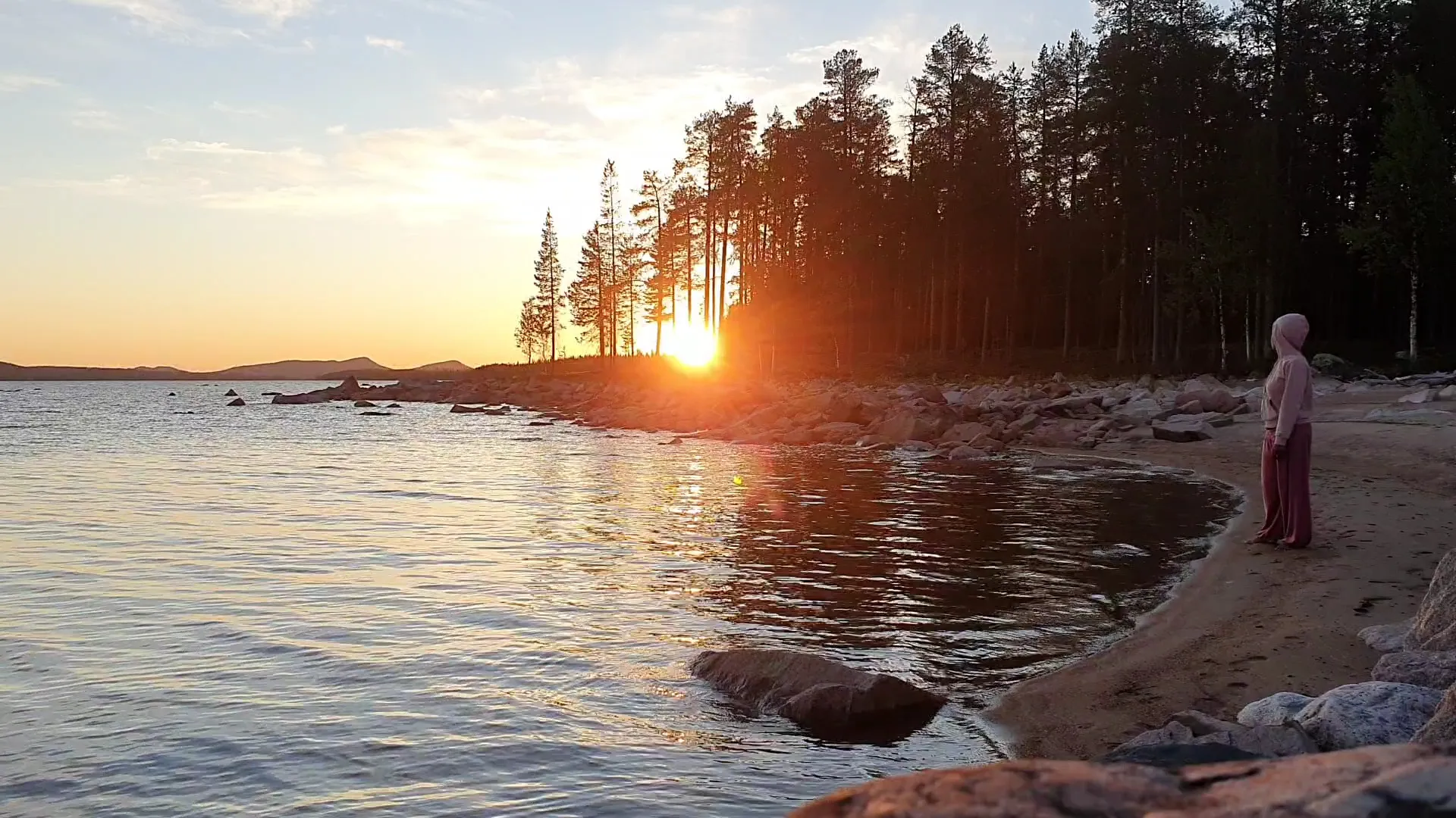 Marlyn standing at the water's edge under the Nordic midnight sun
